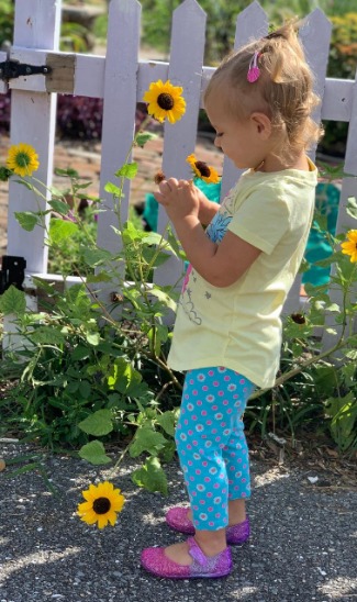 Girl Smelling Sunflower